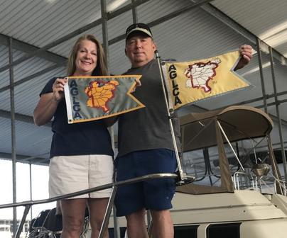 Couple Standing on Boat Holding Boat Flags