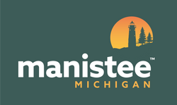 Green background with manistee in white letters, small gold circle with green lighthouse and pine tree.